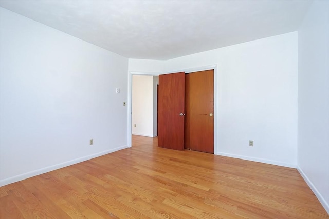 spare room featuring light wood-style flooring and baseboards