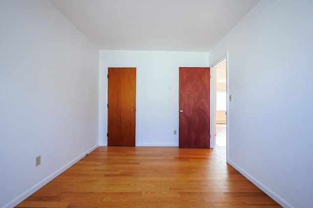 unfurnished room with light wood finished floors and baseboards