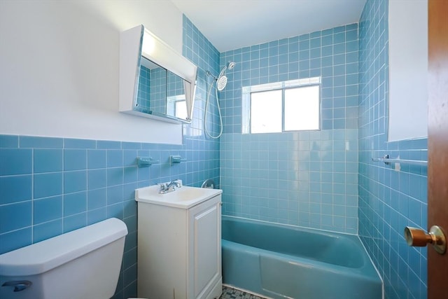 bathroom featuring toilet, tub / shower combination, tile walls, and vanity