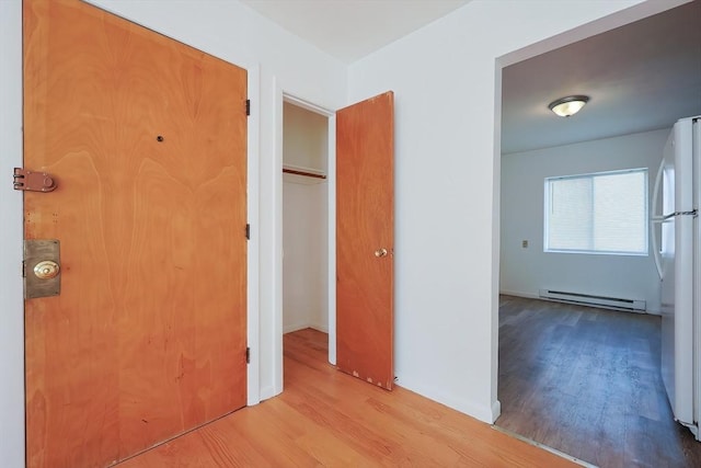 hall featuring a baseboard heating unit and wood finished floors