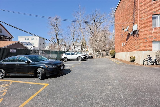 uncovered parking lot featuring fence