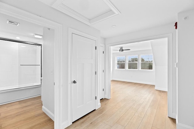 hallway featuring visible vents, baseboards, light wood-style floors, and attic access