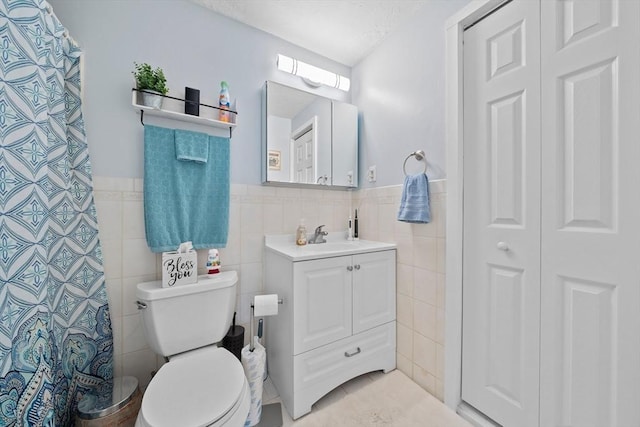 79 Fountain Unit 5, Weymouth, MA 02190 - bathroom with toilet, tile walls, wainscoting, and vanity