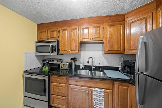 79 Fountain Unit 5, Weymouth, MA 02190 - kitchen featuring brown cabinets, appliances with stainless steel finishes, a sink, dark stone counters, and decorative backsplash