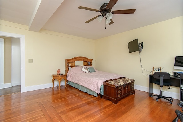 bedroom with hardwood / wood-style floors, ceiling fan, and beam ceiling