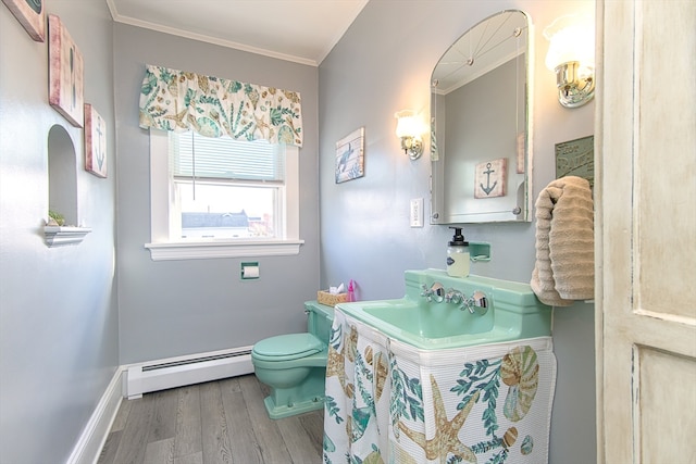 bathroom featuring ornamental molding, vanity, baseboard heating, hardwood / wood-style flooring, and toilet