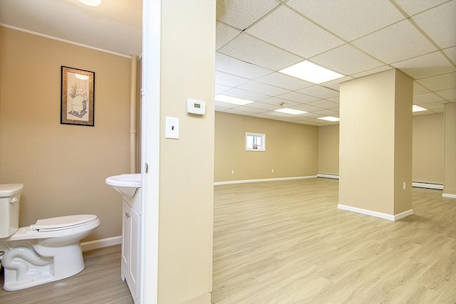 191 Providence St, Putnam, CT 06260 - basement with wood finished floors, baseboard heating, a drop ceiling, and a baseboard radiator