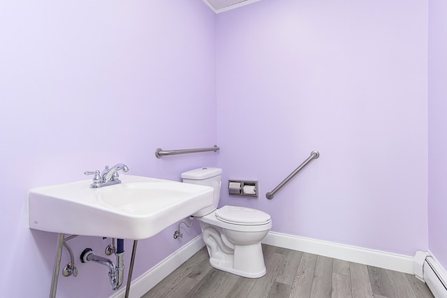 bathroom featuring hardwood / wood-style floors, toilet, and baseboard heating