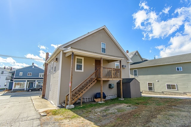 rear view of property featuring a storage shed