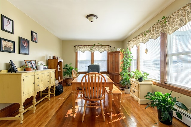 dining room featuring baseboard heating and light hardwood / wood-style flooring