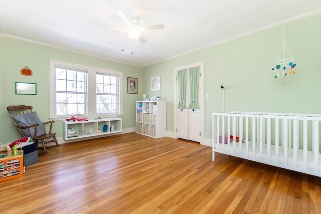 bedroom with crown molding, baseboards, ceiling fan, and wood finished floors