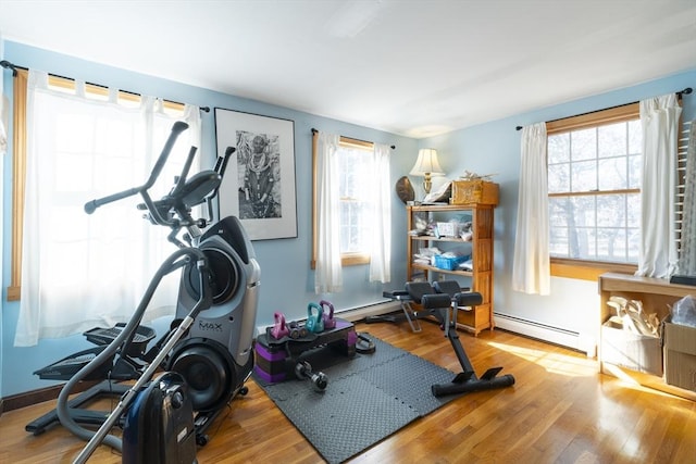 exercise room featuring light wood-type flooring, plenty of natural light, and baseboard heating