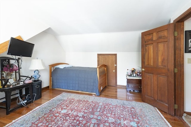 bedroom featuring vaulted ceiling, wood finished floors, and baseboards