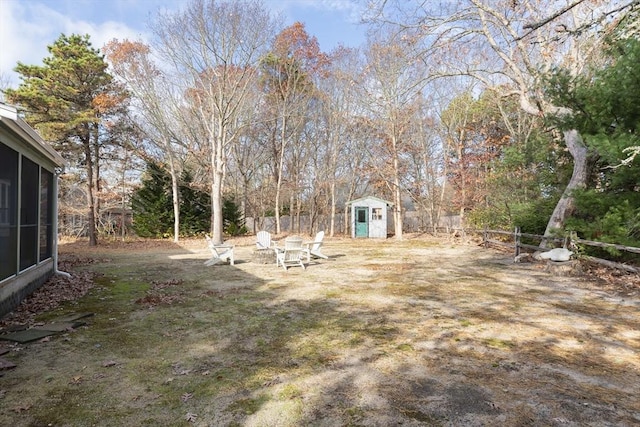 view of yard with fence private yard, an outdoor structure, and a storage unit