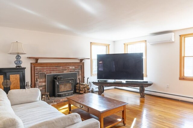 living room with a wall unit AC and light wood-style flooring