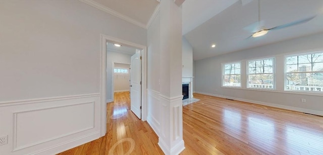 unfurnished living room featuring crown molding, lofted ceiling, and light hardwood / wood-style floors