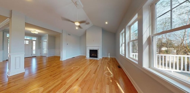 unfurnished living room featuring ceiling fan, lofted ceiling, and light wood-type flooring