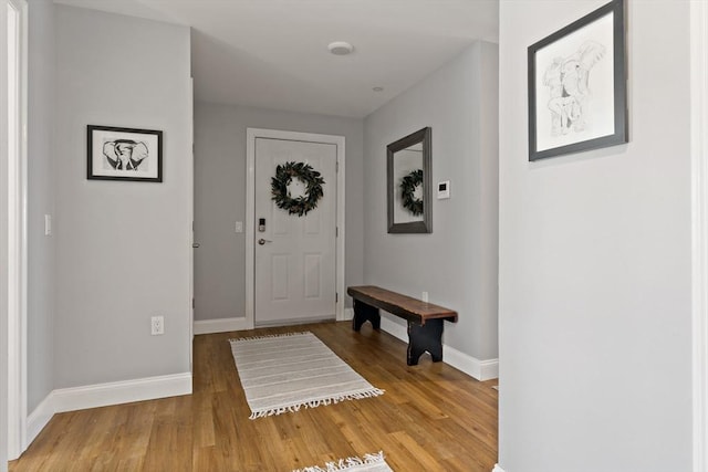 foyer entrance with light wood-style flooring and baseboards