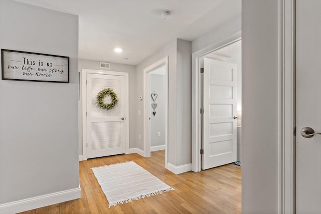 entryway with light wood finished floors, visible vents, and baseboards