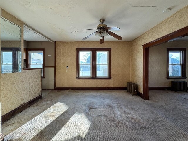 unfurnished living room featuring carpet and radiator heating unit