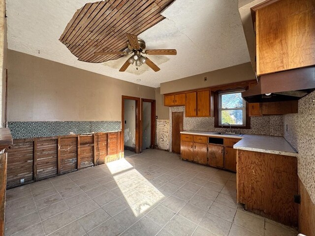 kitchen with ceiling fan, sink, backsplash, a textured ceiling, and light tile patterned flooring