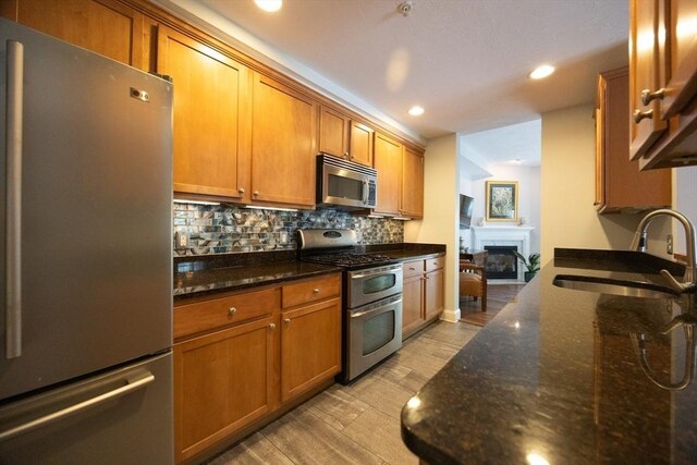140 Commonwealth Ave Unit 38, North Attleboro, MA 02763 - kitchen featuring appliances with stainless steel finishes, a sink, light wood-type flooring, brown cabinets, and recessed lighting