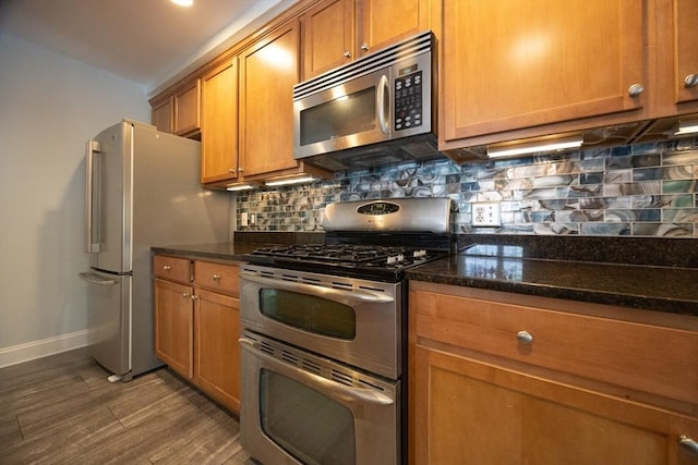 140 Commonwealth Ave Unit 38, North Attleboro, MA 02763 - kitchen featuring stainless steel appliances, baseboards, dark wood-type flooring, brown cabinets, and backsplash