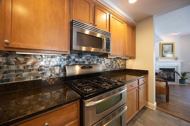 140 Commonwealth Ave Unit 38, North Attleboro, MA 02763 - kitchen featuring stainless steel appliances, dark stone countertops, baseboards, and backsplash