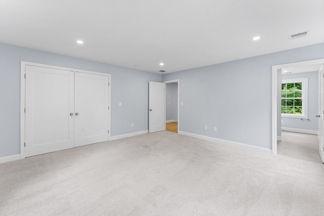 unfurnished bedroom featuring light carpet