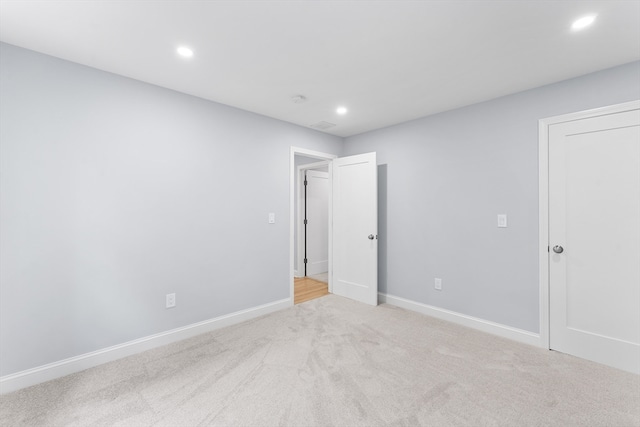 unfurnished room featuring light colored carpet