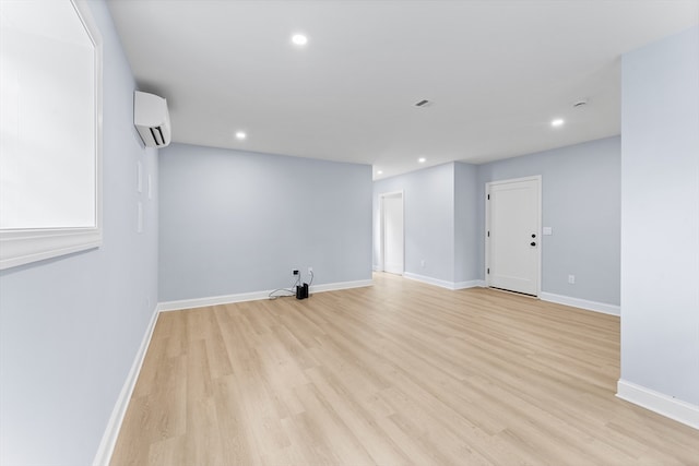 empty room featuring light hardwood / wood-style flooring and a wall mounted air conditioner