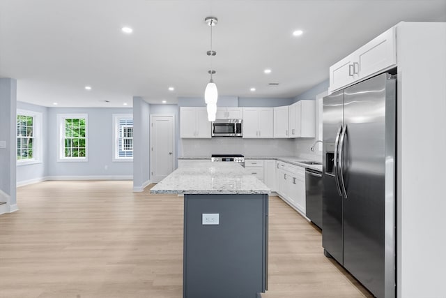 kitchen with appliances with stainless steel finishes, light hardwood / wood-style flooring, decorative backsplash, sink, and light stone counters