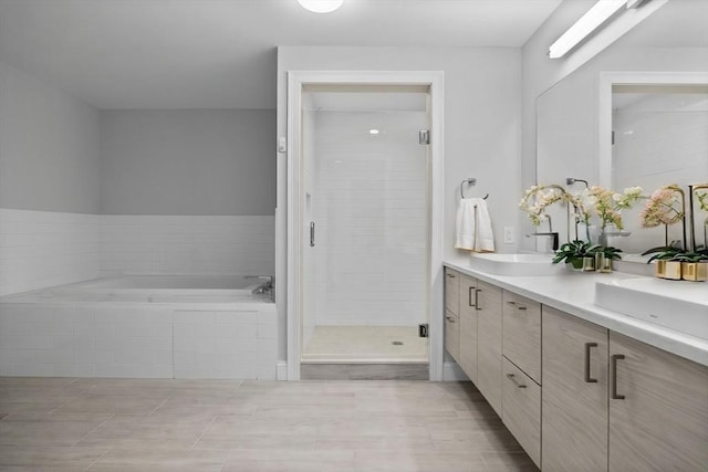 full bath featuring a bath, a sink, a shower stall, and double vanity