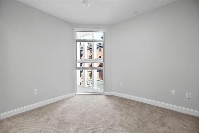 spare room featuring baseboards and carpet