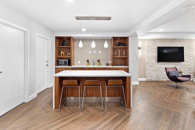 bar with stainless steel microwave, pendant lighting, tasteful backsplash, and a sink