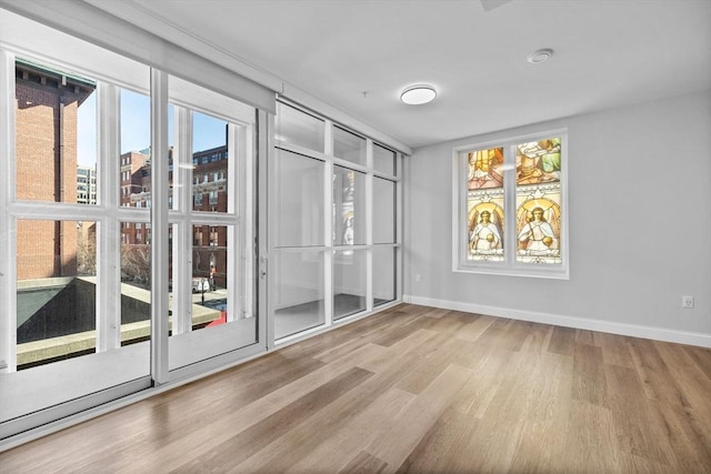 empty room featuring wood finished floors and baseboards