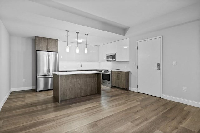 kitchen with white cabinetry, a center island, dark wood-style flooring, and stainless steel appliances