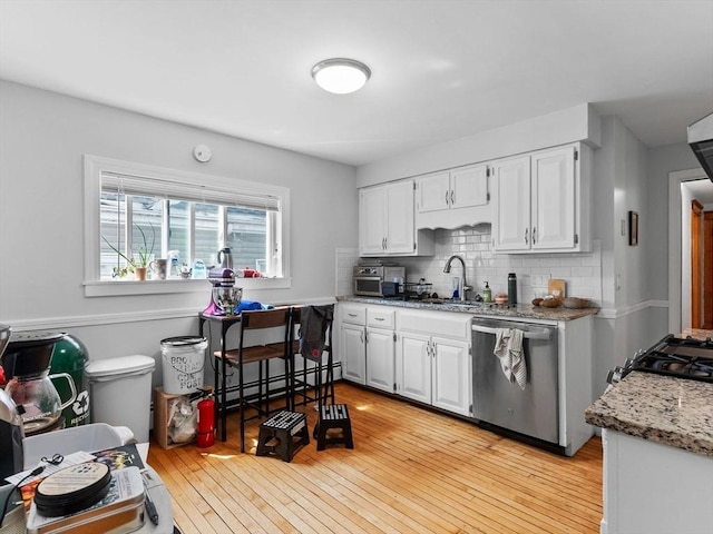 kitchen with light wood-style flooring, white cabinetry, dishwasher, and tasteful backsplash