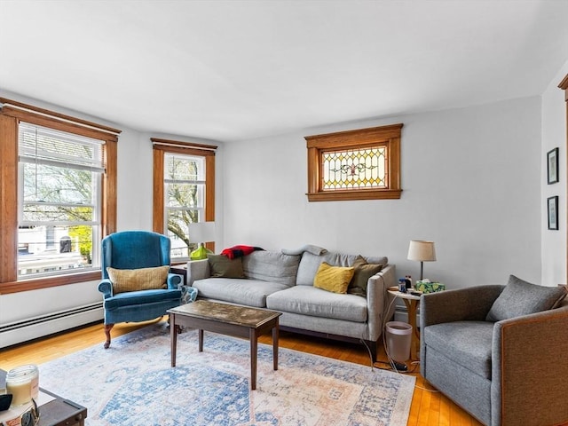 living room with light wood-type flooring and a baseboard radiator