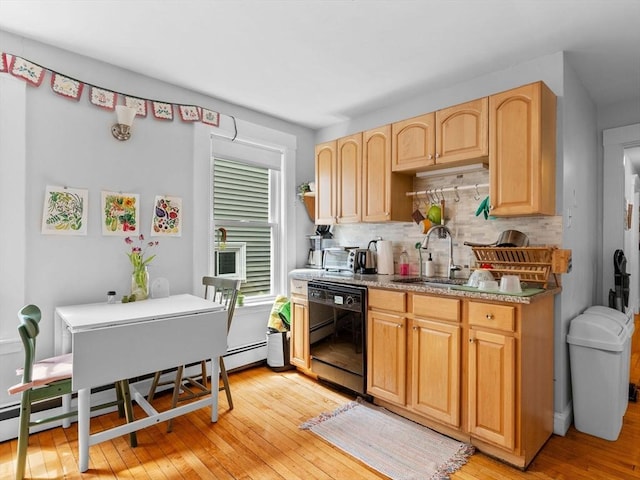 kitchen with backsplash, dishwasher, a sink, a baseboard heating unit, and light wood-style flooring