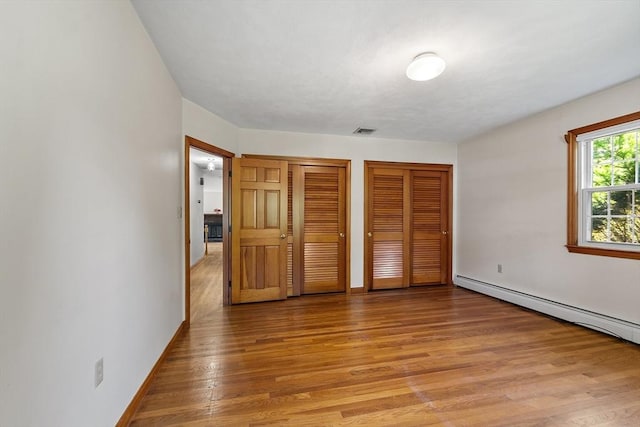 15 Greenbrook Rd, Hamilton, MA 01982 - unfurnished bedroom featuring two closets, light wood finished floors, and baseboard heating