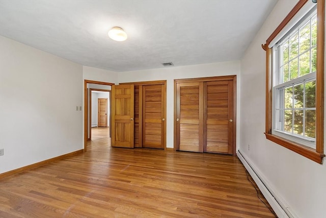 15 Greenbrook Rd, Hamilton, MA 01982 - unfurnished bedroom featuring a baseboard radiator, multiple closets, and light wood-style floors