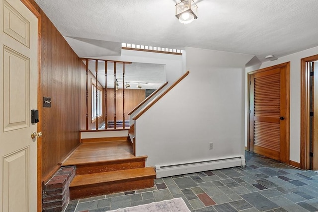 15 Greenbrook Rd, Hamilton, MA 01982 - stairs with a baseboard heating unit, stone finish flooring, a textured ceiling, and wood walls