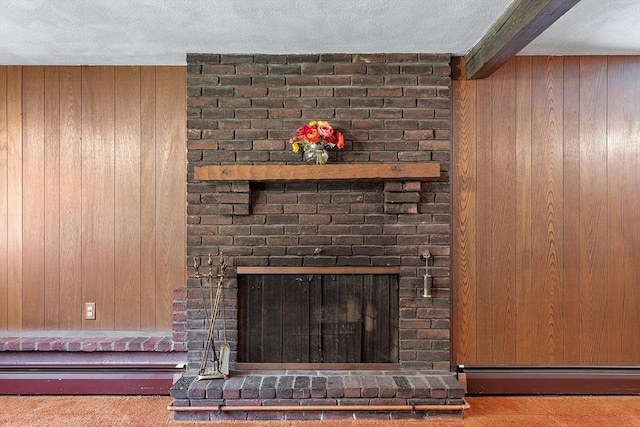 15 Greenbrook Rd, Hamilton, MA 01982 - detailed view of a brick fireplace, beamed ceiling, wooden walls, a textured ceiling, and a baseboard heating unit