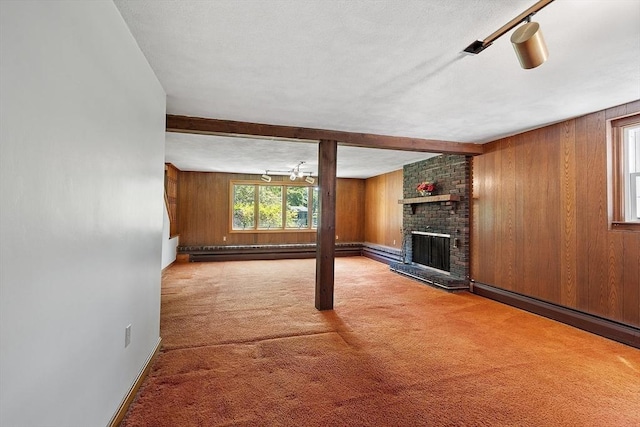 15 Greenbrook Rd, Hamilton, MA 01982 - unfurnished living room with wood walls, a fireplace, carpet floors, beamed ceiling, and a baseboard radiator