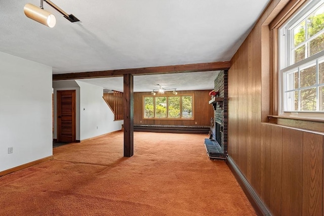 15 Greenbrook Rd, Hamilton, MA 01982 - unfurnished living room with carpet, wooden walls, a brick fireplace, a baseboard radiator, and beam ceiling