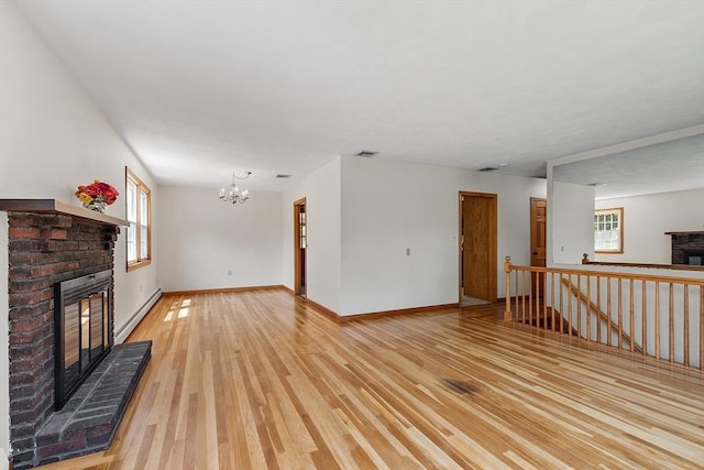 15 Greenbrook Rd, Hamilton, MA 01982 - unfurnished living room with a fireplace, baseboard heating, light wood-style floors, and a chandelier