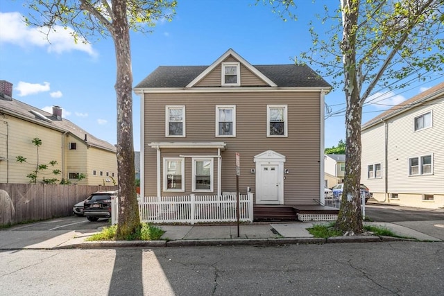 view of front of home with uncovered parking and a fenced front yard