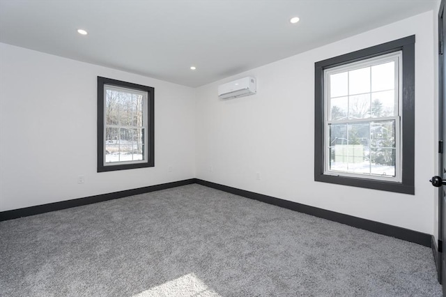 unfurnished room with a wealth of natural light, carpet floors, and a wall mounted AC