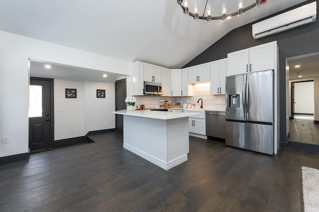 kitchen with white cabinetry, appliances with stainless steel finishes, a wall mounted AC, and sink